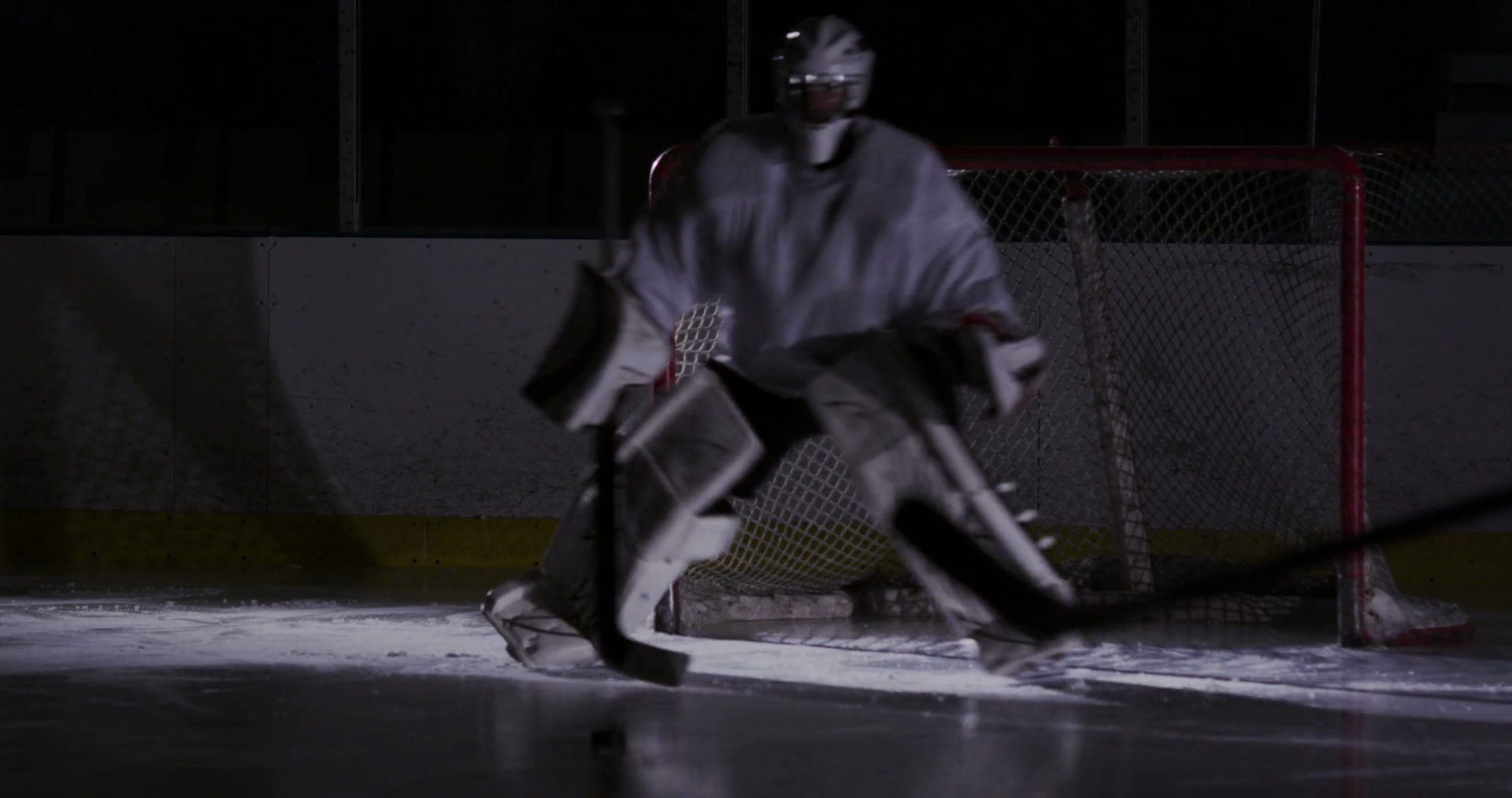 Canadian hockey goalie in red jersey making a save